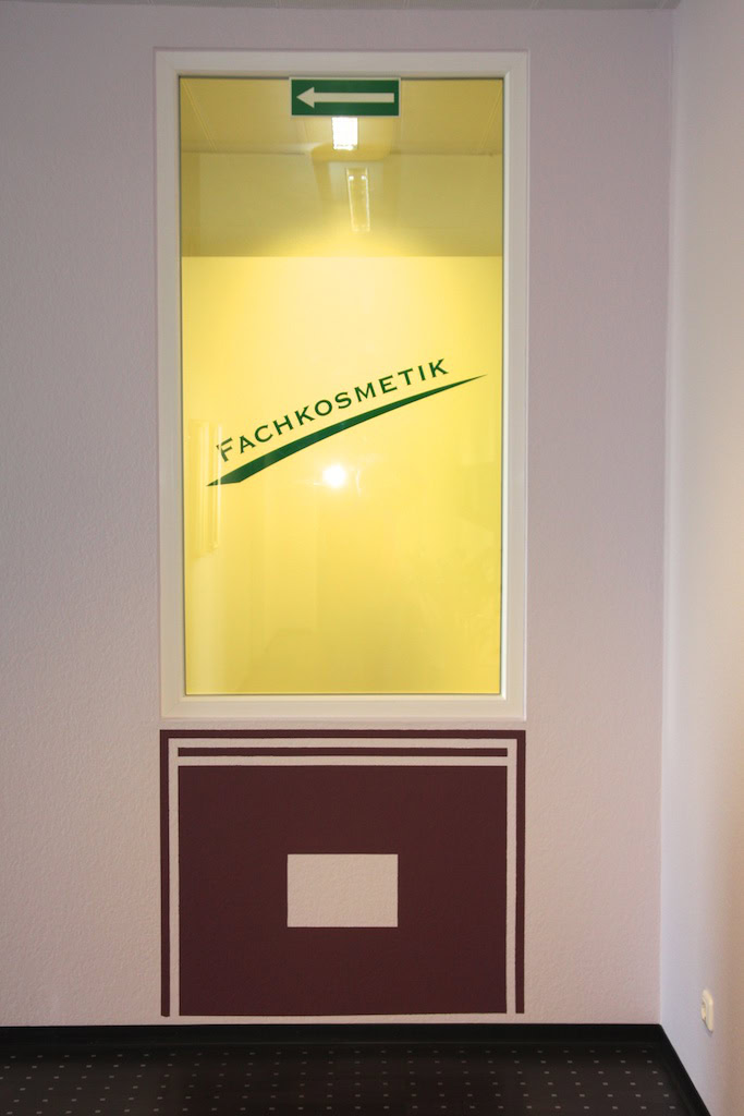 Gelbes Fenster mit Fachkosmetik-Aufschrift.