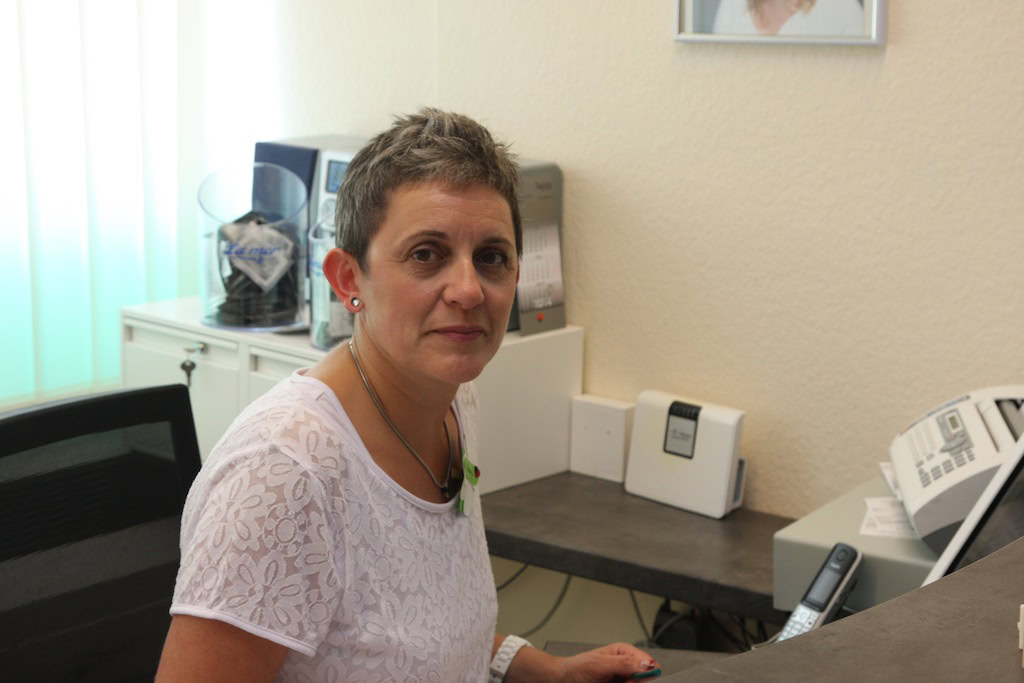 Frau sitzt an Schreibtisch im Büro.